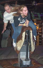 Photo: 2 people riding mechanical bull