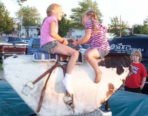 Photo little girls riding mechanical bull